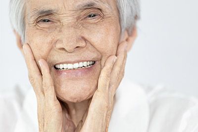 woman loving the look of her new dental implants from Danos Dental