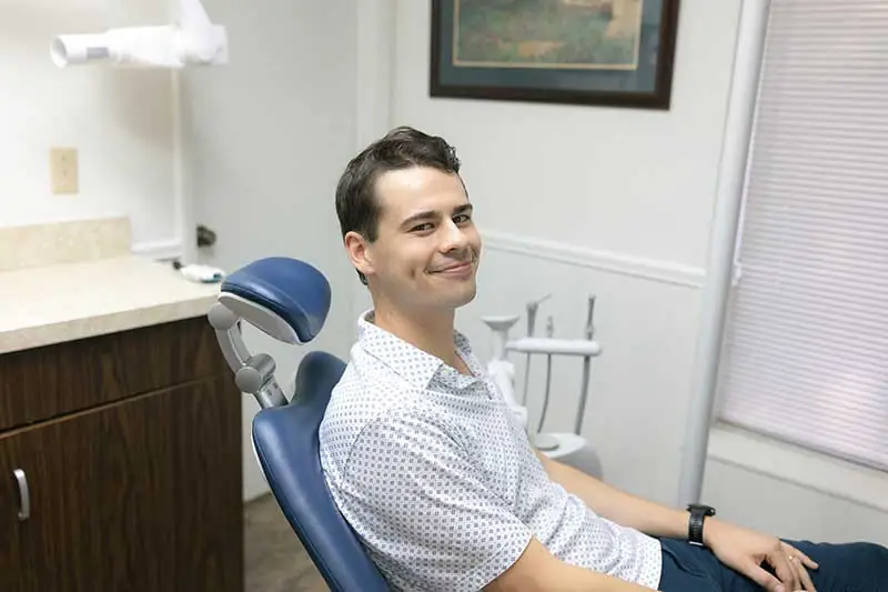 Male periodontal patient smiling and sitting in dental chair at Danos Dental
