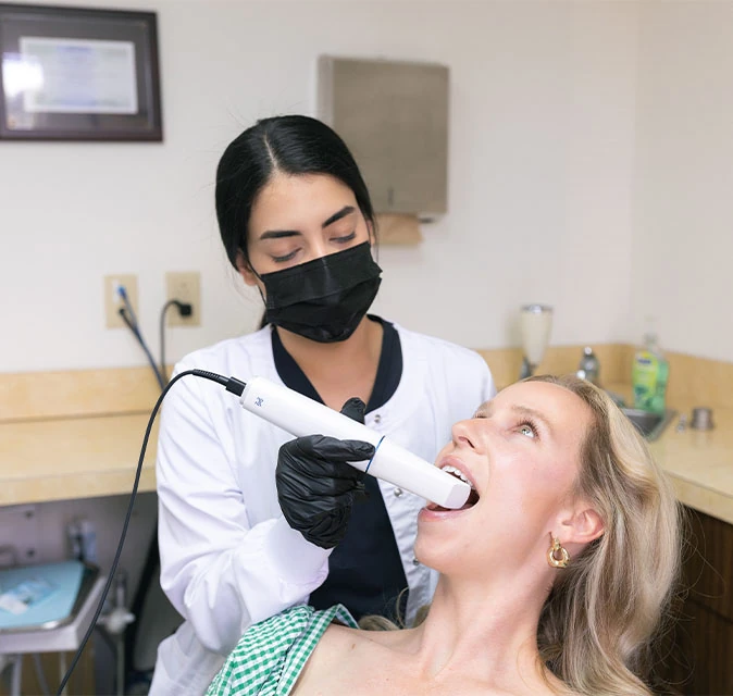 Dental hygienist using an intraoral scanner on a female patient